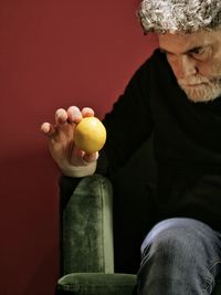 Portrait of senior man sitting on table