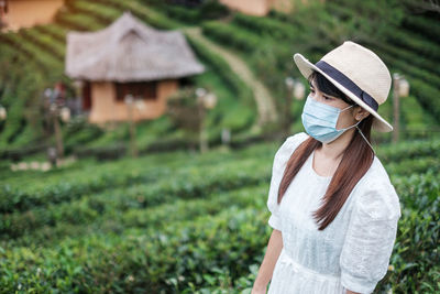 Rear view of woman with hat on grass