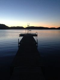 Pier on lake at sunset