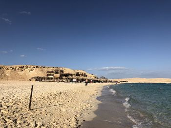 Scenic view of beach against blue sky