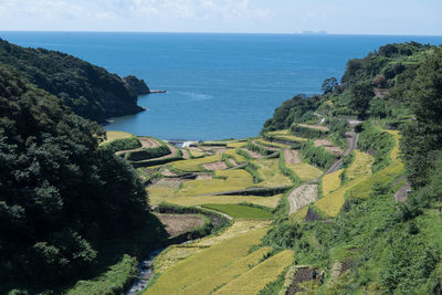 High angle view of rice terrance and sea against sky in saga city, kyushu, japan.