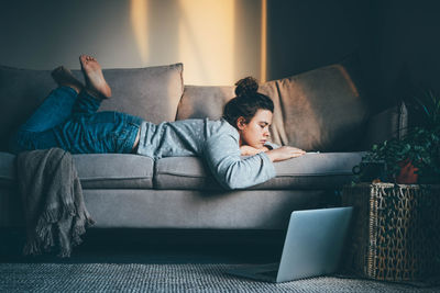 Portrait of woman sitting on sofa at home