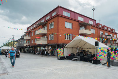 People at market in city against sky