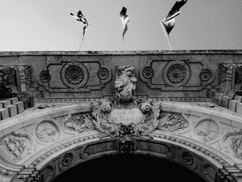 Directly below shot of carvings on historic building against clear sky