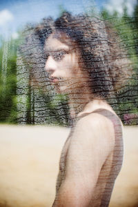 Portrait of beautiful woman against trees