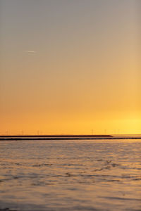 Scenic view of sea against orange sky