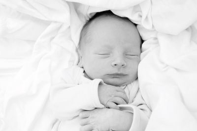 Close-up of cute baby boy sleeping on bed