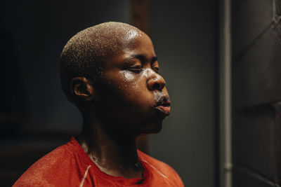 Tired female athlete with eyes closed after working out in gym