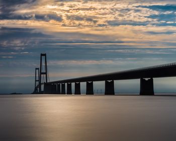 Bridge over sea against sky during sunset