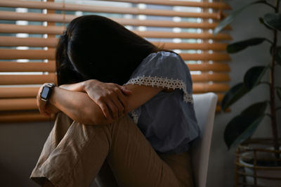 Rear view of woman looking through window