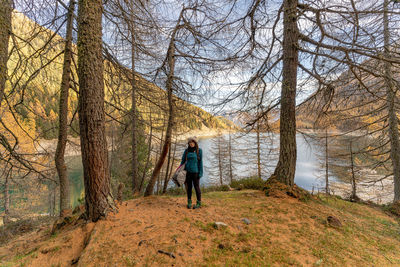 Portrait of woman standing against river in forest