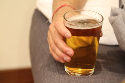 Close-up of hand holding beer glass