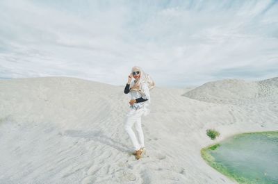 Full length of woman standing at desert