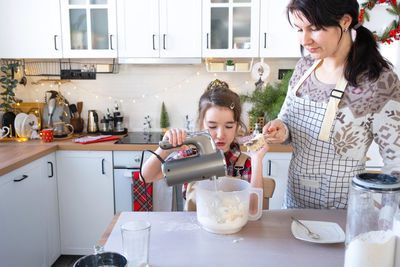 Portrait of young woman sitting in kitchen