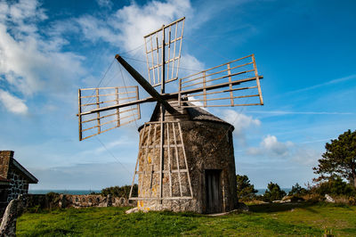 Traditional windmill on landscape against sky