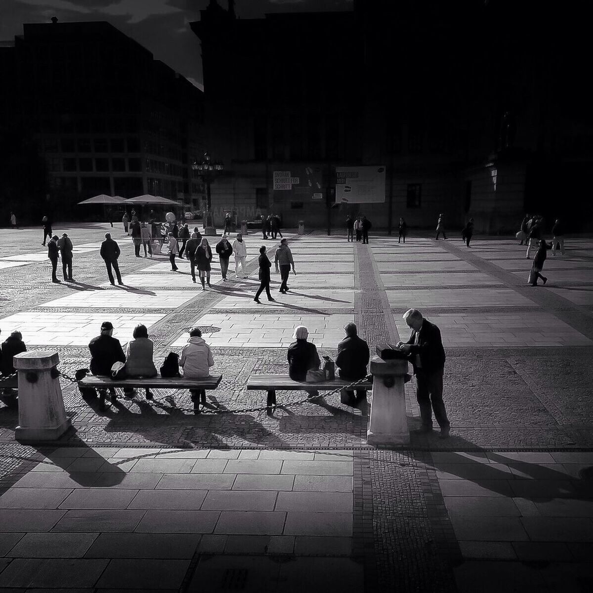 large group of people, building exterior, architecture, built structure, person, street, men, city, walking, city life, lifestyles, leisure activity, mixed age range, city street, town square, sidewalk, building, shadow, night