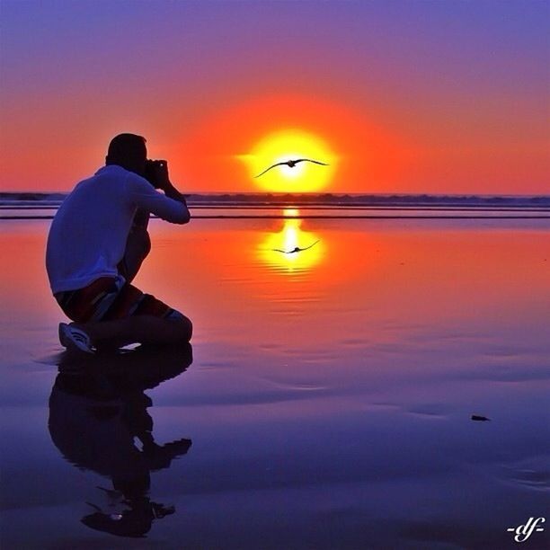 sunset, orange color, water, silhouette, sea, lifestyles, men, horizon over water, scenics, leisure activity, sun, beauty in nature, sky, standing, reflection, tranquility, tranquil scene, idyllic