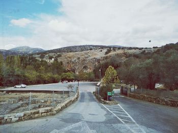 Road by mountain against sky