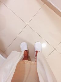 Low section of woman standing on tiled floor