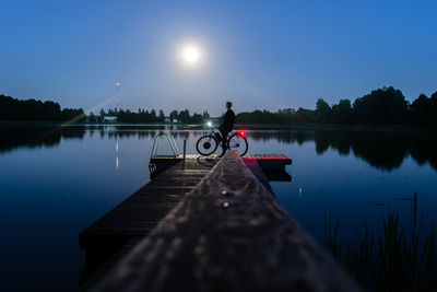 Pier on lake against sky at night