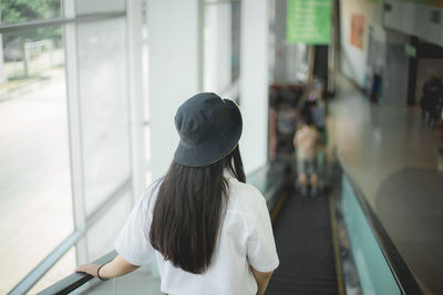 Rear view of woman standing in bus