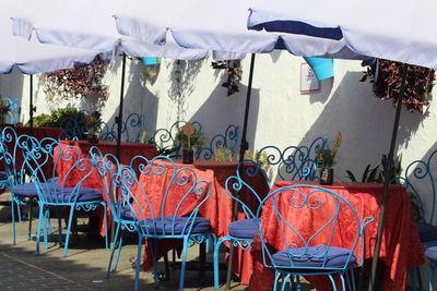 Empty chairs and tables against buildings