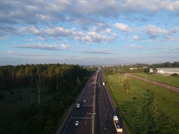 High angle view of road amidst trees against sky