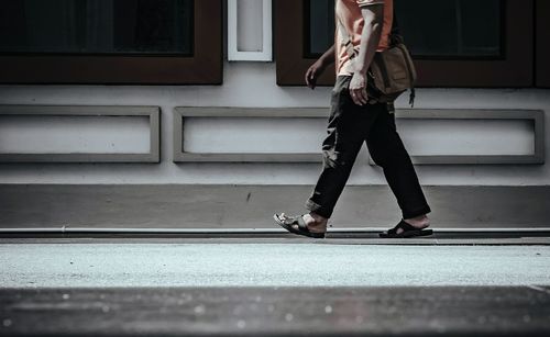 Low section of woman standing on zebra crossing