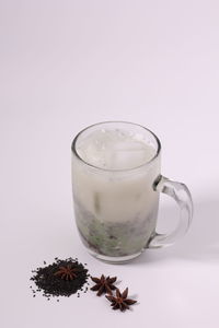 Close-up of beer glass on table against white background