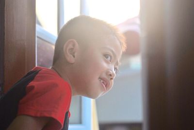 Close-up of boy looking through window