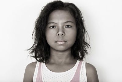 Portrait of cute girl standing against white background
