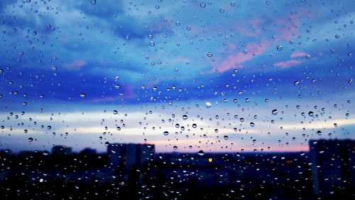 Sky seen through wet glass window during rainy season