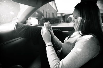 Woman using mobile phone in car