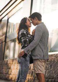 Low angle view of young couple romancing while standing outdoors