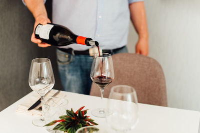 Male waiter serving red wine in a restaurant