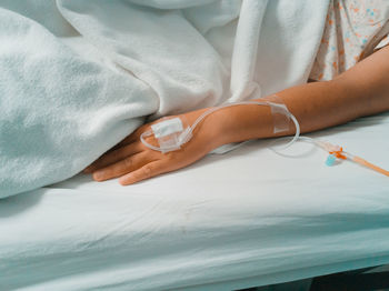 Midsection of woman lying on bed