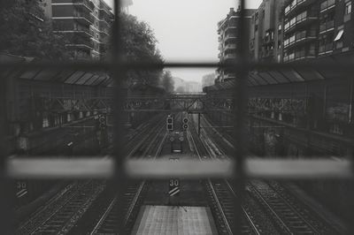Railroad tracks in city against sky