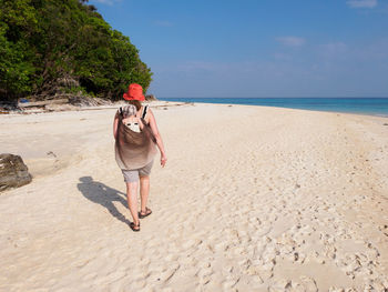 Woman standing on beach against sea