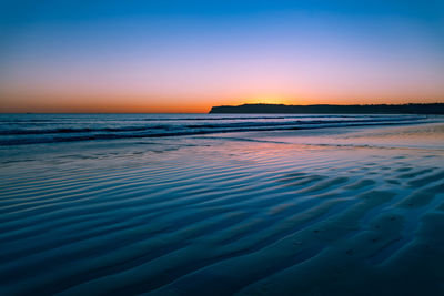 Scenic view of sea against clear sky during sunset