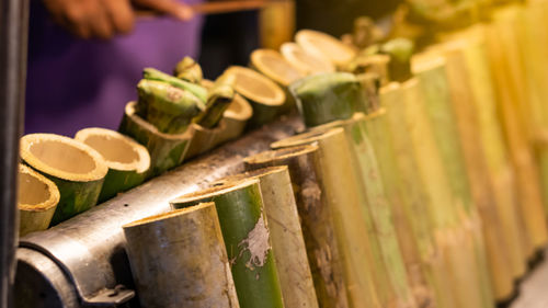 Midsection of person standing by bamboos