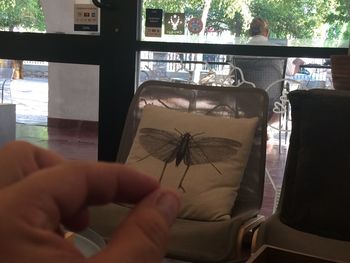 Midsection of man holding glass window