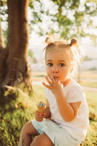 Portrait of young woman sitting on field