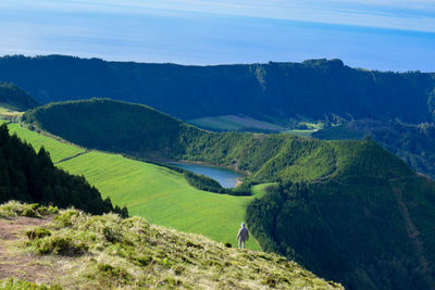 Man in a scenic view of mountains and laggon against sky