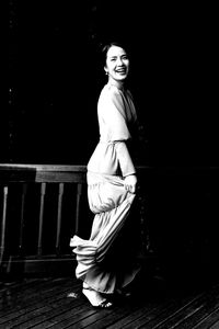 Portrait of smiling woman standing against railing