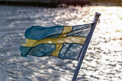 Close-up of worn out swedish flag on small boat