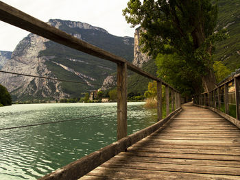 Footbridge over lake against mountains