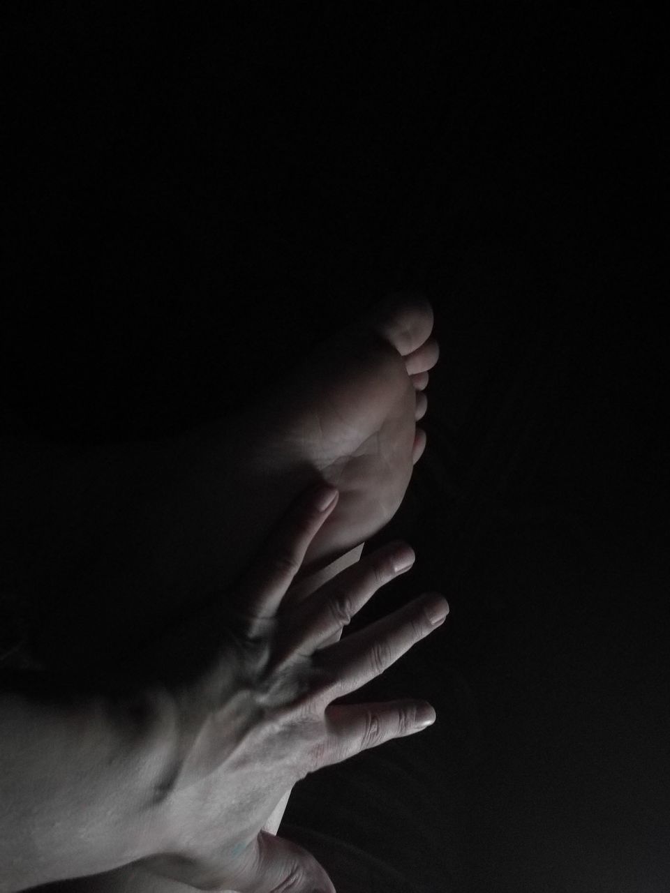 CLOSE-UP OF HAND AGAINST BLACK BACKGROUND