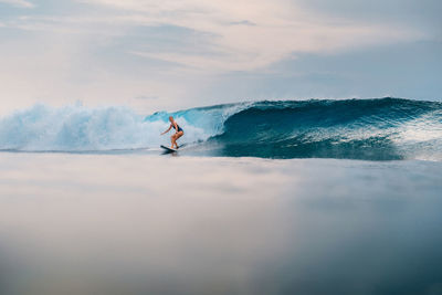 Man surfing on sea against sky