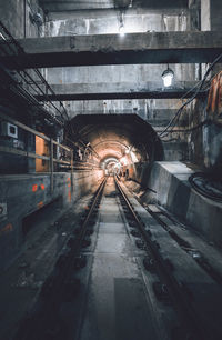 Railroad tracks in illuminated tunnel