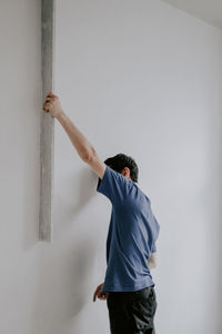 Caucasian plasterer man checks the evenness of the walls after puttying.